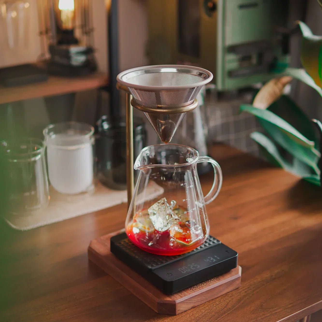 Tea-making setup with glass teapot and filter on a wooden surface